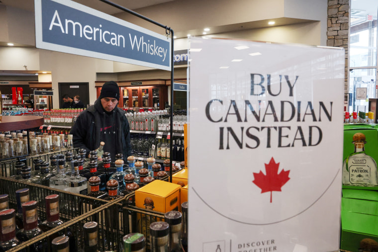 Puste półki pozostają z znakami „Kup Canadian zamiast” po usunięciu pięciu najlepszych amerykańskich marek alkoholowych ze sprzedaży w sklepie alkoholowym BC w Vancouver